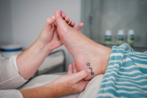 Image of a foot with hands holding reflexology points to support fertility