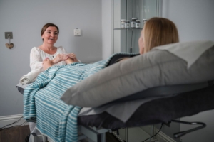 Image of a woman slightly sitting up having reflexology for pregnancy